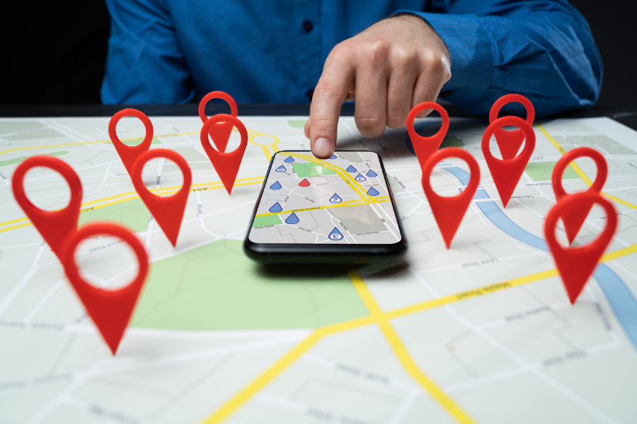 image of a person and phone displaying gps pins on a map